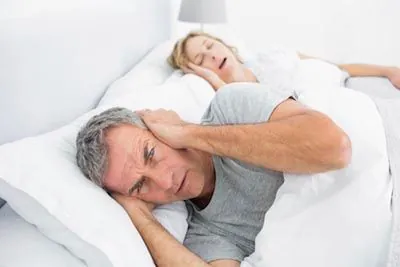 man awake at night due to his wife's snoring from sleep apnea